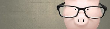 Cropped photo of a piggy bank wearing glasses