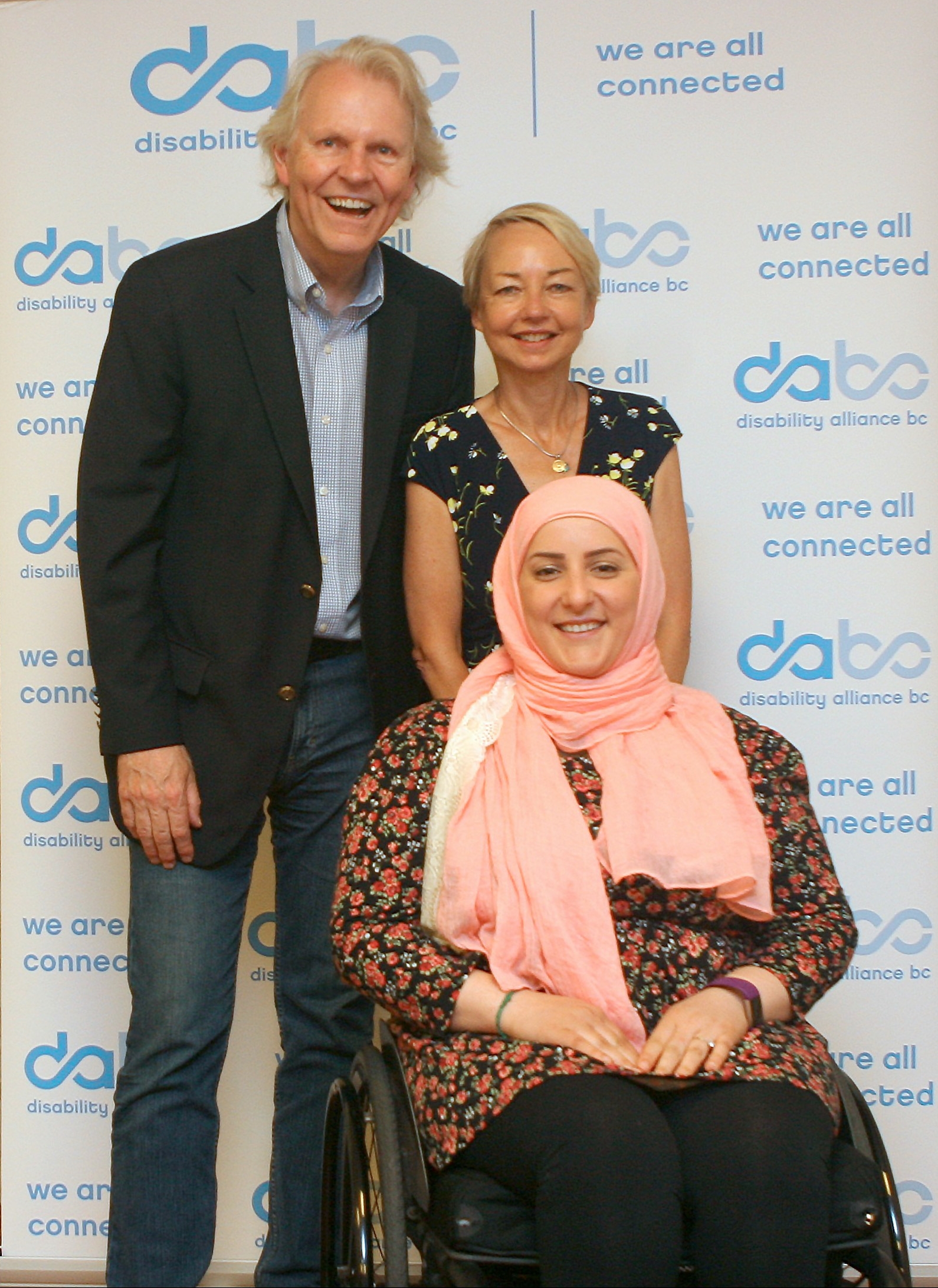 Photo of Michael Prince, Jane Dyson and Jana Husseini in front of the DABC banner